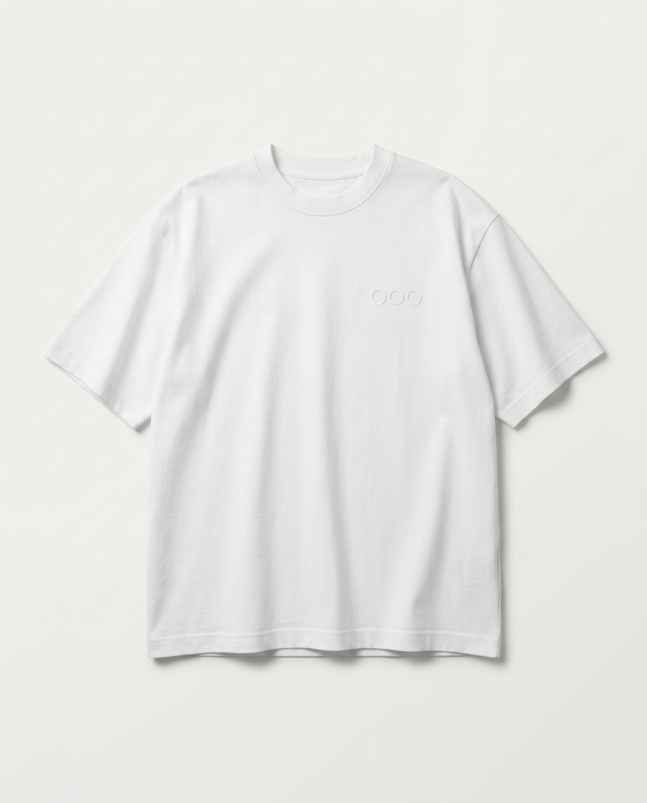 Studio product shot of the front of the oversized white heavyweight tee with the three-ring chest embroidery