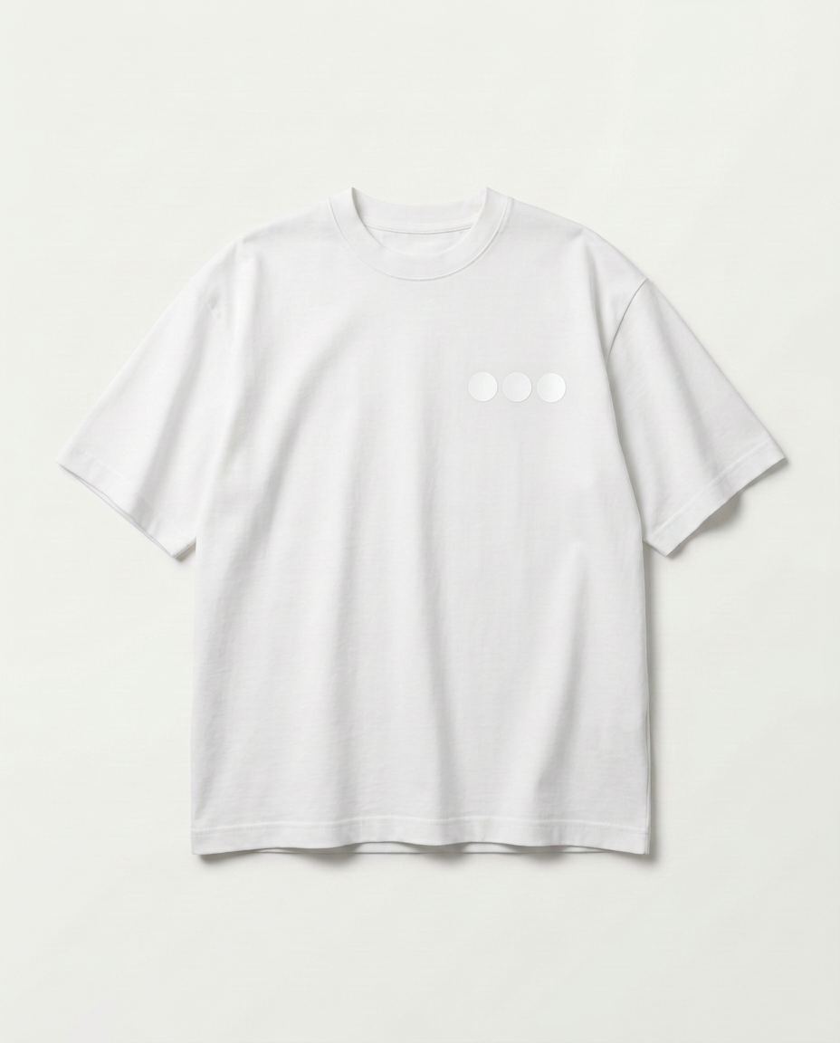 Studio product shot of the front of the oversized white heavyweight tee with the three-ring chest embroidery